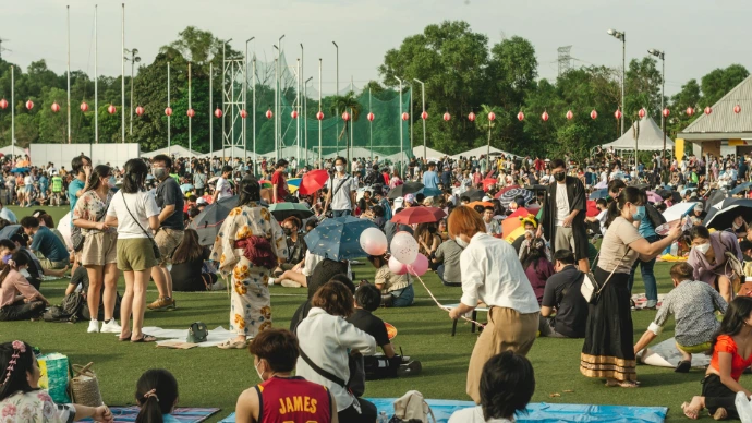 a group of people dancing in a field with a crowd watching