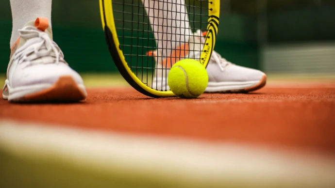 person in white nike sneakers playing tennis